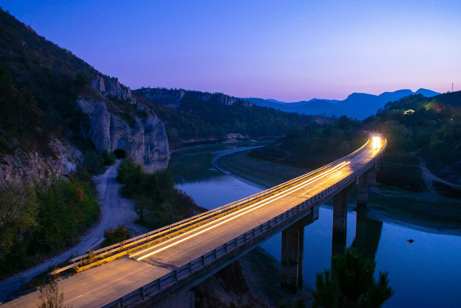 Brücke mit Lichtspuren in der Abenddämmerung zwischen bulgarischen Bergen