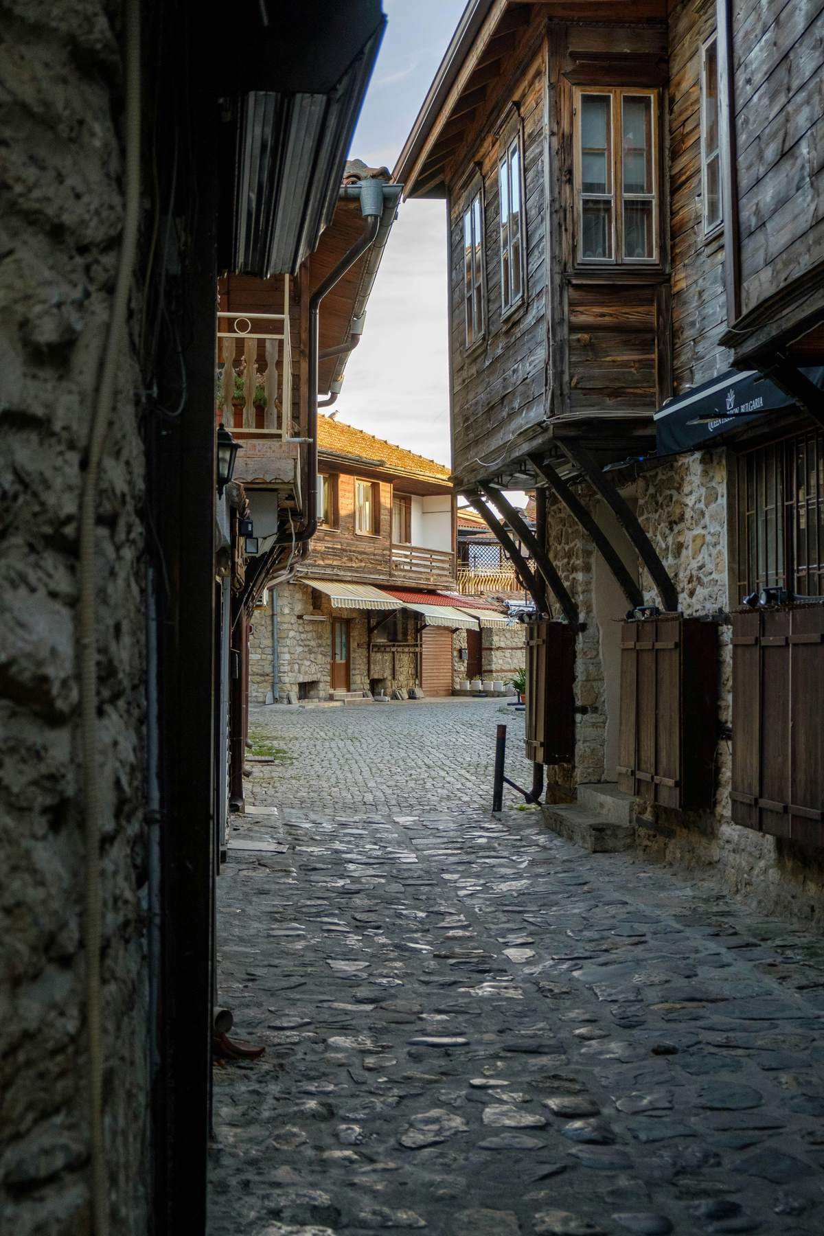 Kopfsteinpflastergasse mit traditionellen Holzhäusern in der Altstadt von Nessebar