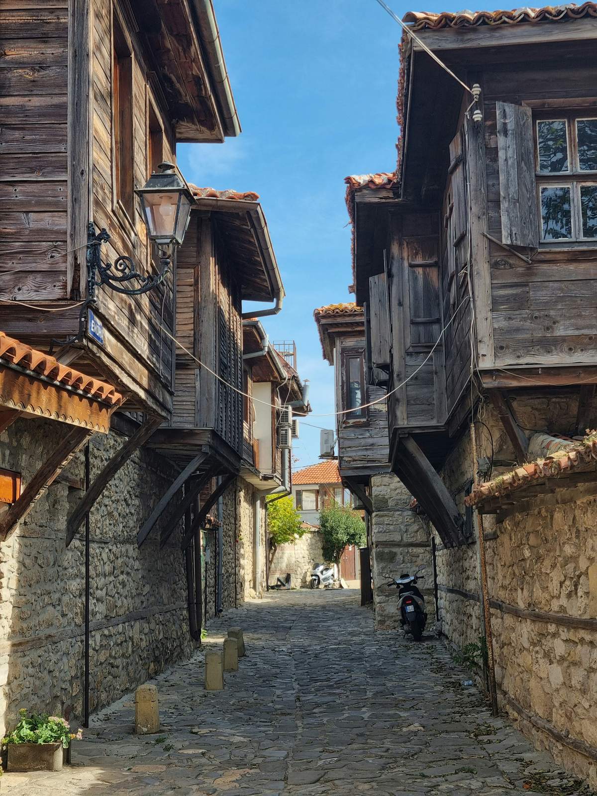 Sonnige Altstadtgasse mit traditionellen Holzhäusern in Bulgarien