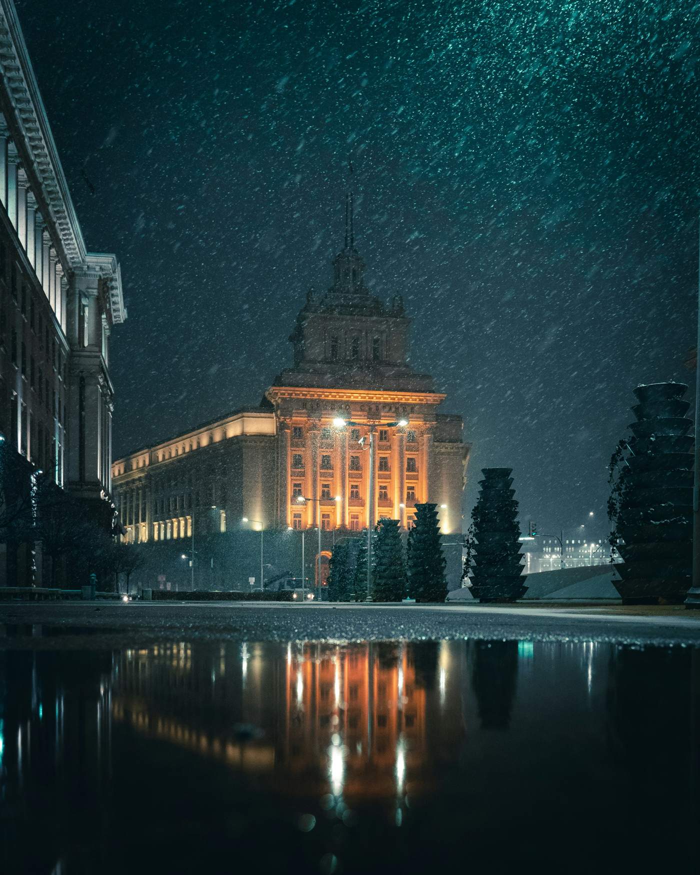 Beleuchtetes Regierungsgebäude in Sofia bei nächtlichem Schneefall
